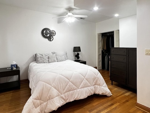 bedroom with a closet, visible vents, baseboards, wood finished floors, and recessed lighting