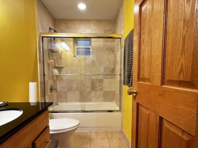 bathroom featuring toilet, shower / bath combination with glass door, tile patterned flooring, and vanity