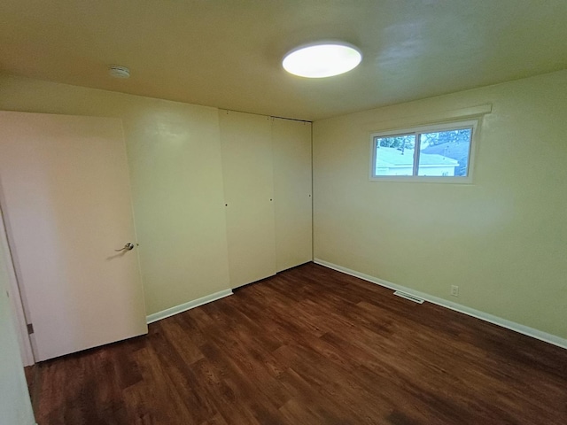 214 Augusta Dr, Mahomet, IL 61853 - unfurnished bedroom featuring dark wood-style flooring, a closet, baseboards, and visible vents