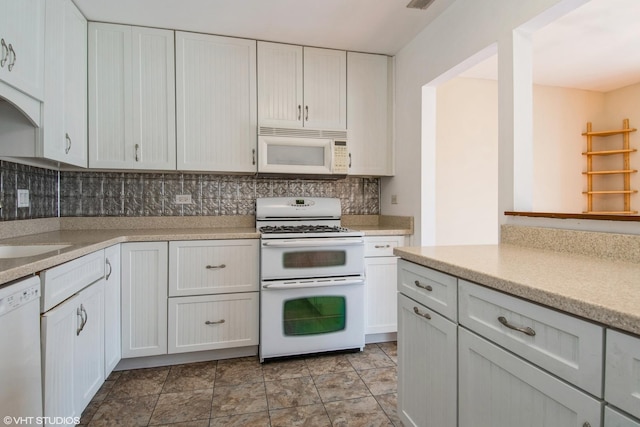 7010 Dover Ct Unit 203, Woodridge, IL 60517 - kitchen featuring white cabinets, light countertops, decorative backsplash, and white appliances