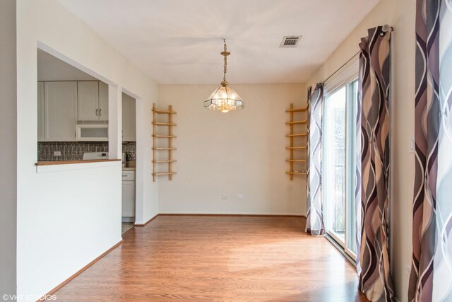 7010 Dover Ct Unit 203, Woodridge, IL 60517 - unfurnished dining area featuring visible vents, baseboards, light wood finished floors, and an inviting chandelier