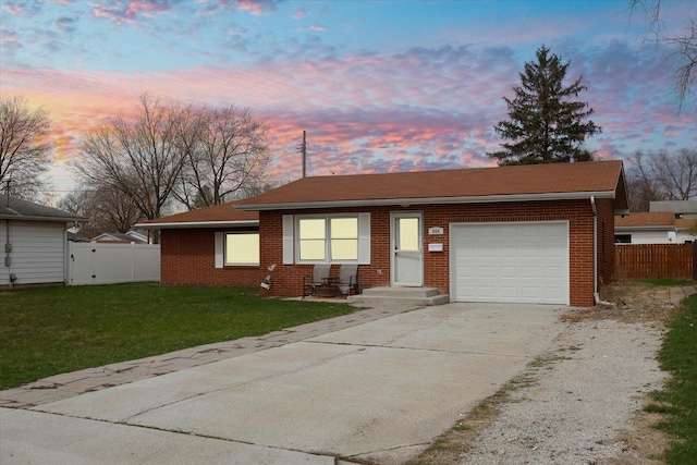 ranch-style home with a front yard, concrete driveway, fence, an attached garage, and brick siding