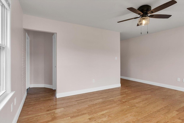 empty room featuring baseboards, light wood-type flooring, and a ceiling fan