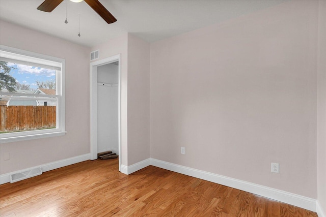 unfurnished bedroom featuring baseboards, visible vents, light wood-style floors, and a ceiling fan