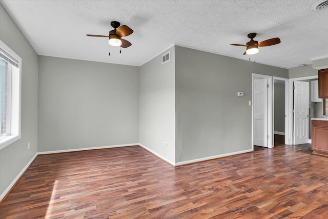 empty room featuring baseboards, visible vents, ceiling fan, and wood finished floors