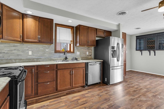 kitchen featuring a sink, tasteful backsplash, appliances with stainless steel finishes, dark wood-style floors, and visible vents
