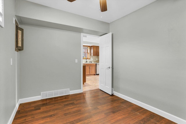 unfurnished room with baseboards, visible vents, wood finished floors, and a ceiling fan