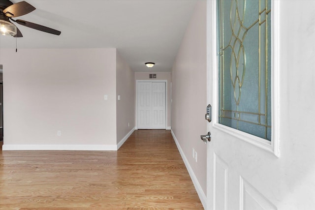 interior space featuring light wood finished floors, baseboards, visible vents, and a ceiling fan
