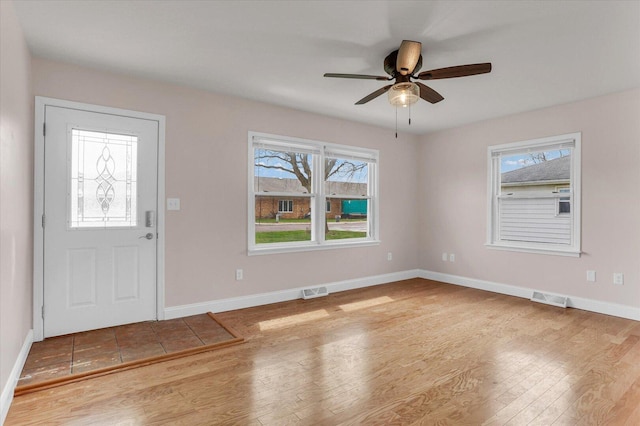 entryway featuring a ceiling fan, wood finished floors, baseboards, and visible vents