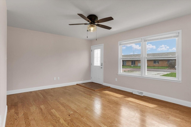 unfurnished room featuring baseboards, light wood-style floors, ceiling fan, and visible vents
