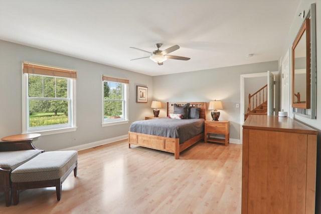 bedroom with baseboards, visible vents, ceiling fan, and light wood-style flooring