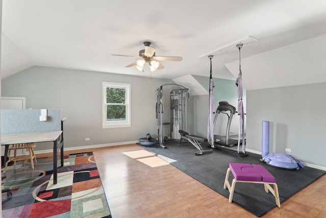 workout area featuring baseboards, wood finished floors, vaulted ceiling, and a ceiling fan
