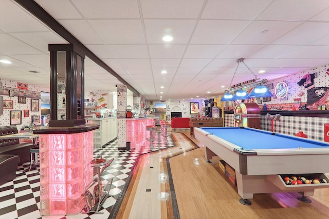 rec room with a bar, wallpapered walls, pool table, and wood finished floors