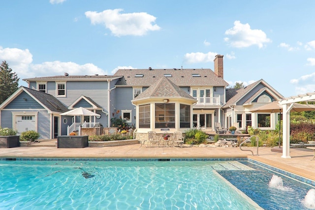 rear view of house featuring a chimney, a fenced in pool, a sunroom, and a patio area