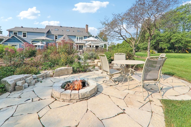 view of patio with outdoor dining area and a fire pit