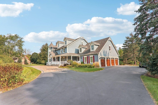 view of front of home with driveway, a porch, and a garage