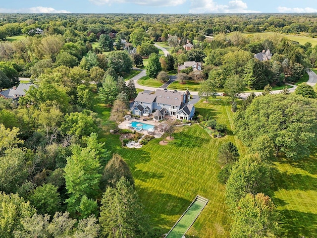 bird's eye view with a wooded view