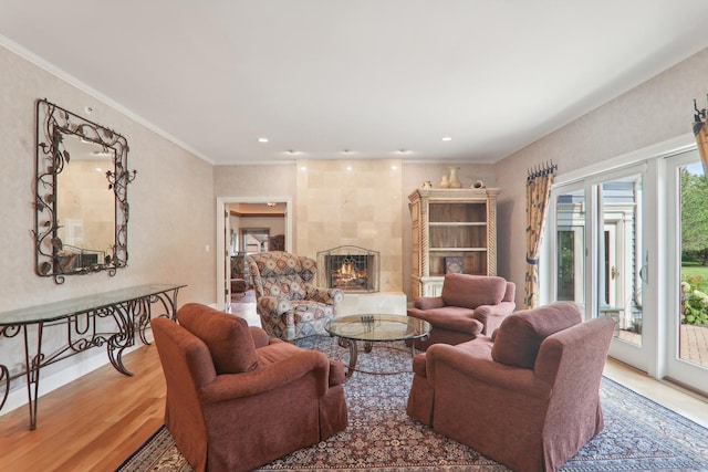 living room with crown molding, wood finished floors, a tile fireplace, and recessed lighting
