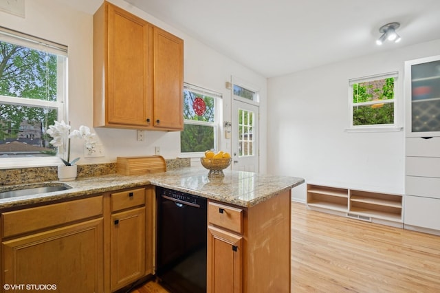4134 S Ellis Ave, Chicago, IL 60653 - kitchen featuring black dishwasher, a peninsula, light wood-type flooring, light stone counters, and brown cabinets