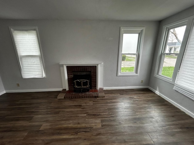 unfurnished living room featuring baseboards and dark wood-type flooring