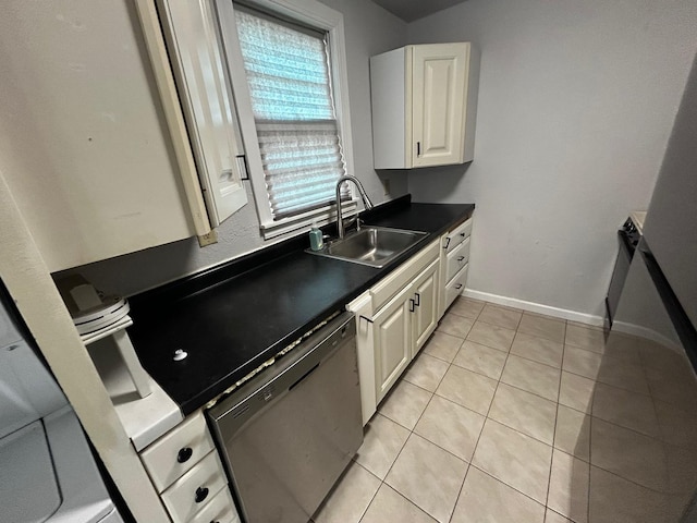 kitchen featuring white cabinetry, light tile patterned floors, a sink, dark countertops, and dishwashing machine