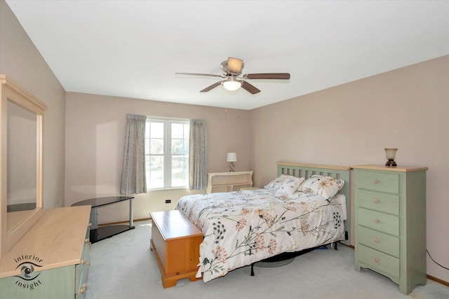 bedroom featuring light carpet, a ceiling fan, and baseboards