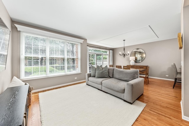 405 Ashbury Ln, Lemont, IL 60439 - living area with attic access, light wood-type flooring, baseboards, and a chandelier