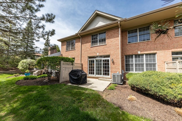 405 Ashbury Ln, Lemont, IL 60439 - back of property featuring central AC, a lawn, brick siding, and a patio area