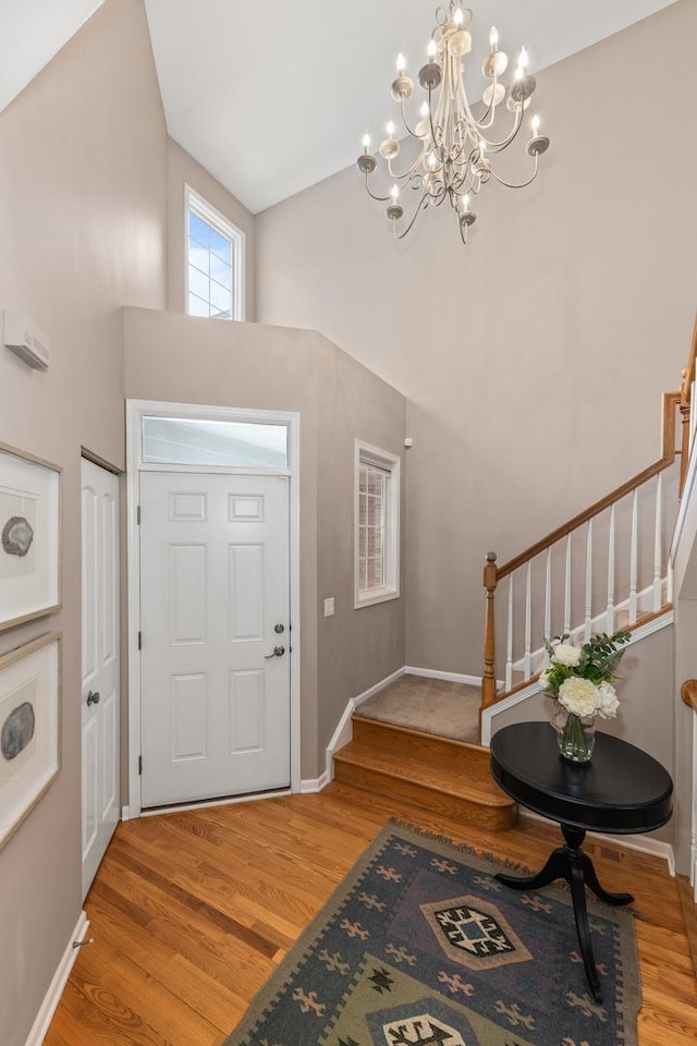 405 Ashbury Ln, Lemont, IL 60439 - foyer featuring stairs, a chandelier, light wood finished floors, a towering ceiling, and baseboards