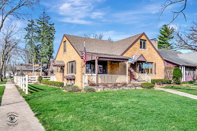 view of front of property with brick siding, a porch, roof with shingles, and a front lawn
