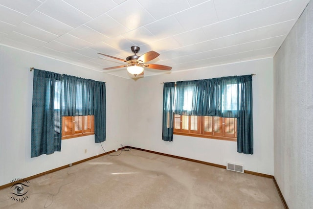 unfurnished room featuring baseboards, carpet flooring, visible vents, and a ceiling fan