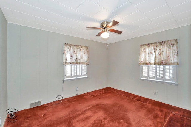 carpeted spare room featuring ceiling fan and visible vents