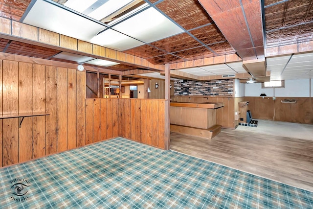 interior space with visible vents, wood finished floors, and wooden walls