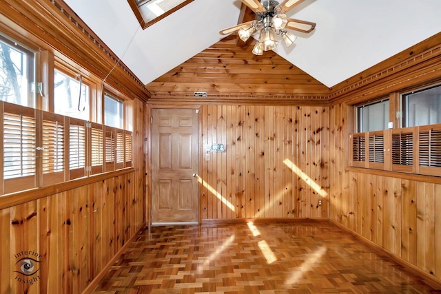 unfurnished room with baseboards, wooden walls, lofted ceiling, and ceiling fan