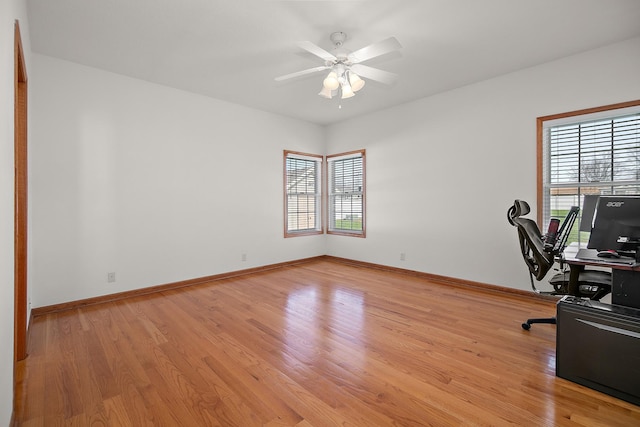 unfurnished office featuring a wealth of natural light, light wood-style flooring, and baseboards