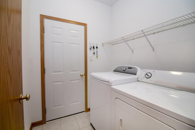 laundry room featuring separate washer and dryer, laundry area, and light tile patterned floors
