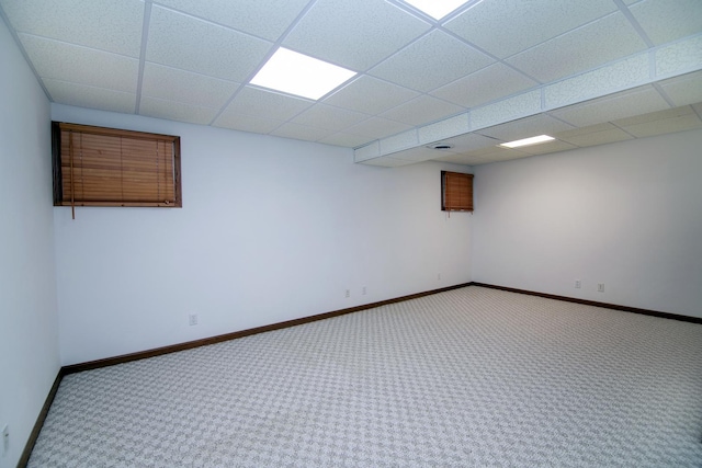 spare room with carpet, baseboards, and a paneled ceiling