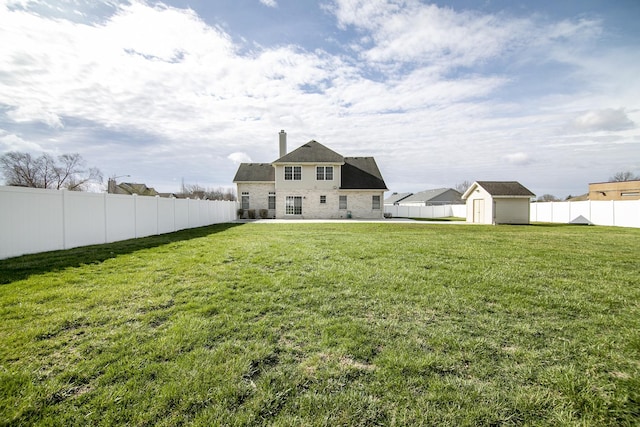 rear view of property with an outdoor structure, a fenced backyard, a storage unit, and a yard