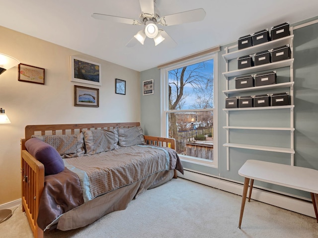 bedroom with a ceiling fan, carpet, and a baseboard heating unit