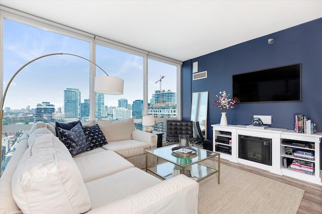 living area with visible vents, floor to ceiling windows, and wood finished floors