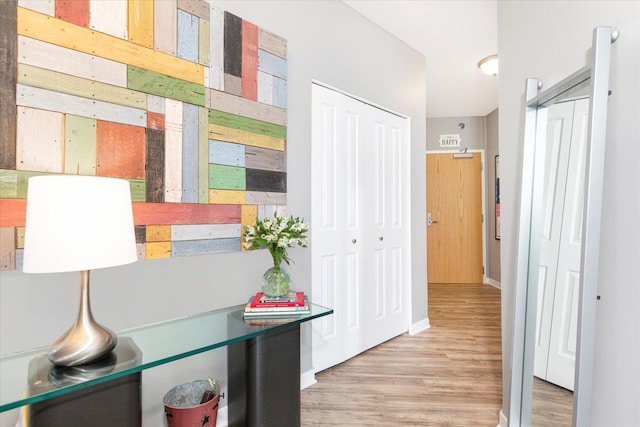 hall with baseboards and wood finished floors
