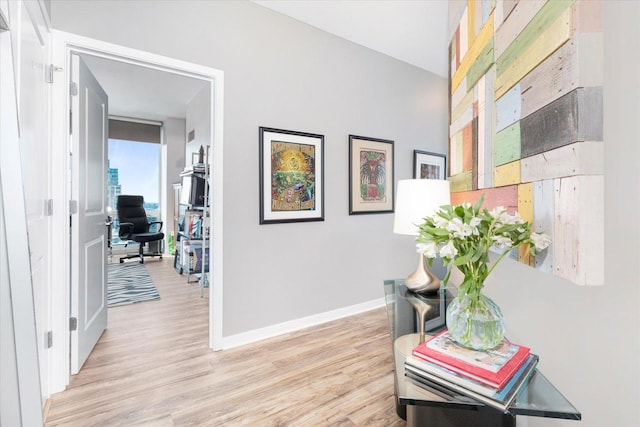 hall with baseboards and light wood-style flooring