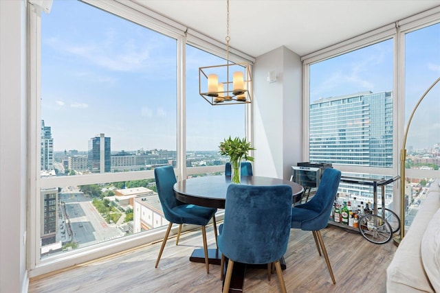 sunroom / solarium featuring a view of city and a chandelier