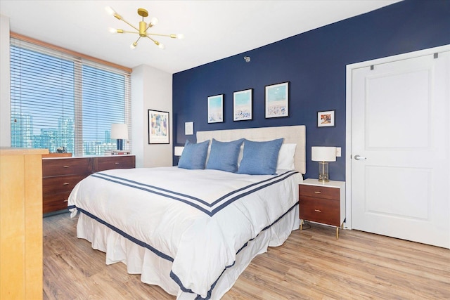 bedroom featuring wood finished floors and a chandelier