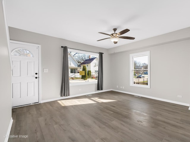 interior space featuring visible vents, wood finished floors, baseboards, and ceiling fan