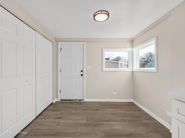entryway with baseboards and wood finished floors