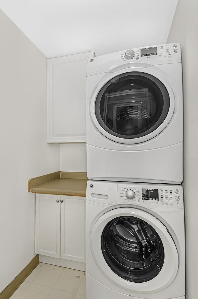 1459 W Melrose St Unit 1N, Chicago, IL 60657 - laundry area with stacked washer and clothes dryer, cabinet space, and baseboards