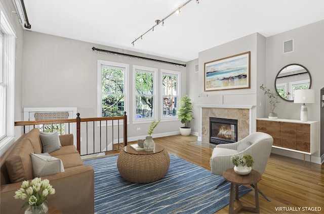 1459 W Melrose St Unit 1N, Chicago, IL 60657 - living room with rail lighting, a tiled fireplace, wood finished floors, and baseboards
