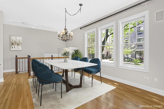 1459 W Melrose St Unit 1N, Chicago, IL 60657 - dining space featuring baseboards, a chandelier, and track lighting