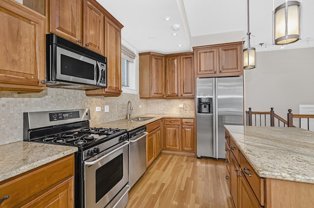 1459 W Melrose St Unit 1N, Chicago, IL 60657 - kitchen featuring stainless steel appliances, a sink, light wood-style flooring, light stone counters, and brown cabinetry